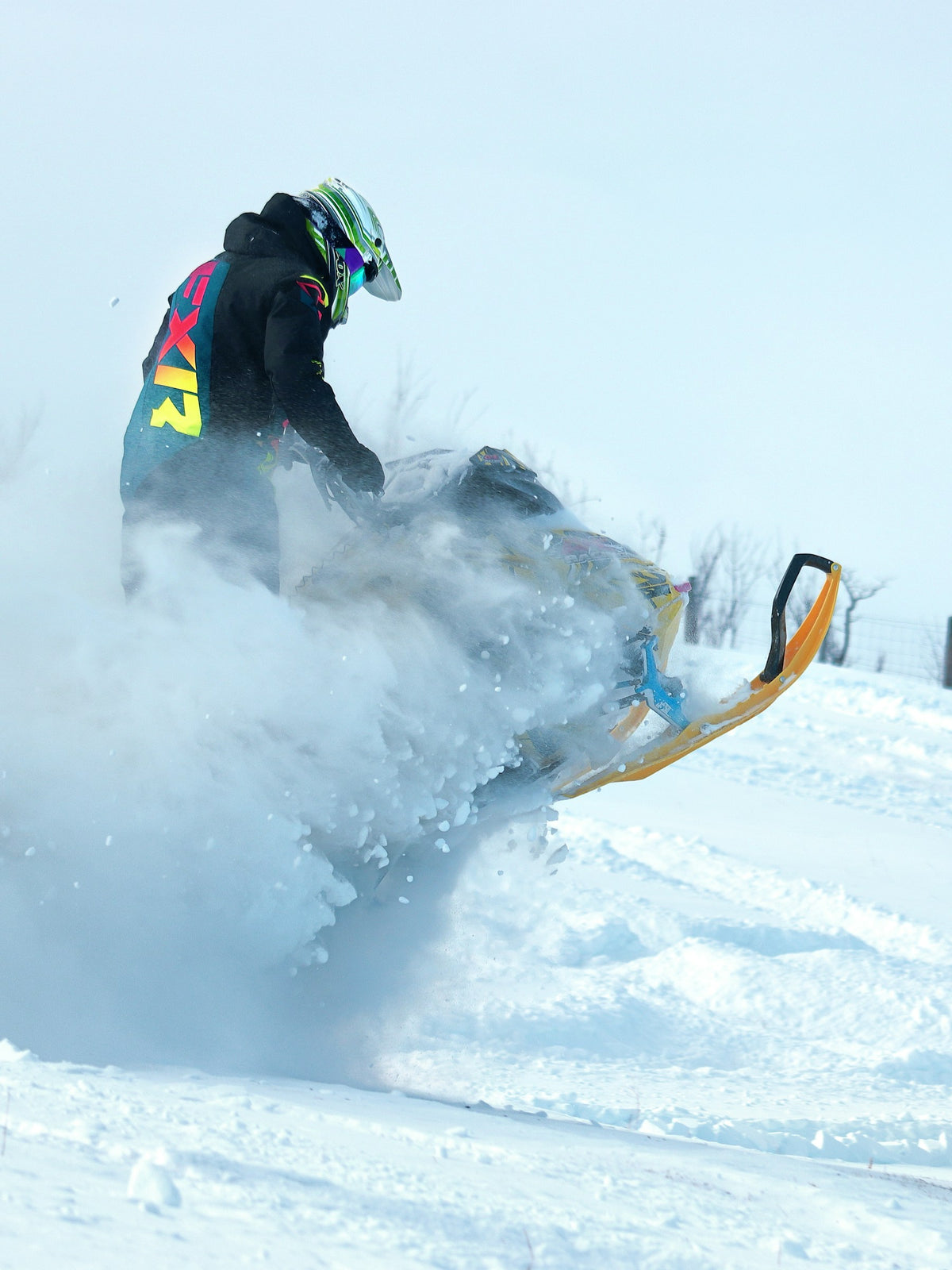 Snowmobile rider carving through deep powder