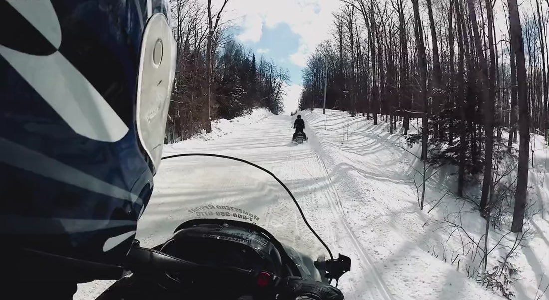 Snowmobile trail ride through the woods